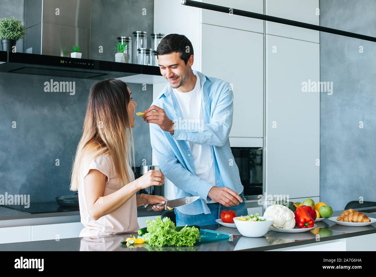 Coppia giovane la cottura di un vegetariano prima colazione di mattina in una cucina luminosa Foto Stock