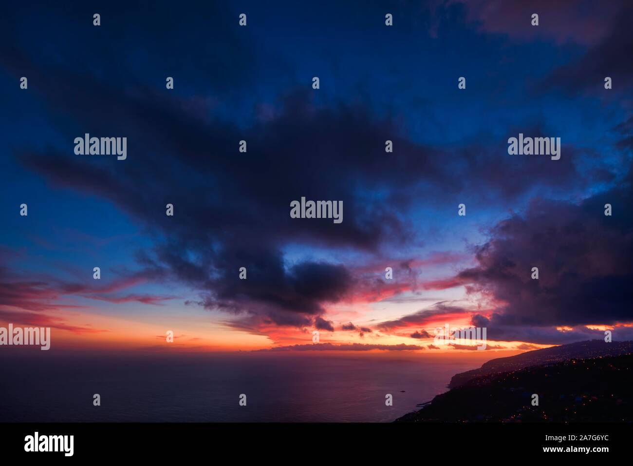 Drammatica cielo nuvoloso al tramonto, ripida costa vicino Arco da Calheta, Isola di Madeira, Portogallo Foto Stock