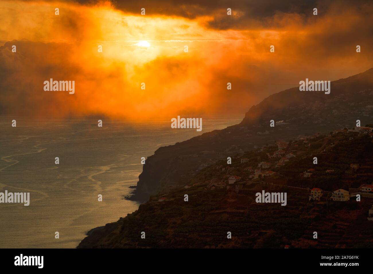 Drammatica cielo nuvoloso al tramonto, ripida costa vicino Arco da Calheta, Isola di Madeira, Portogallo Foto Stock