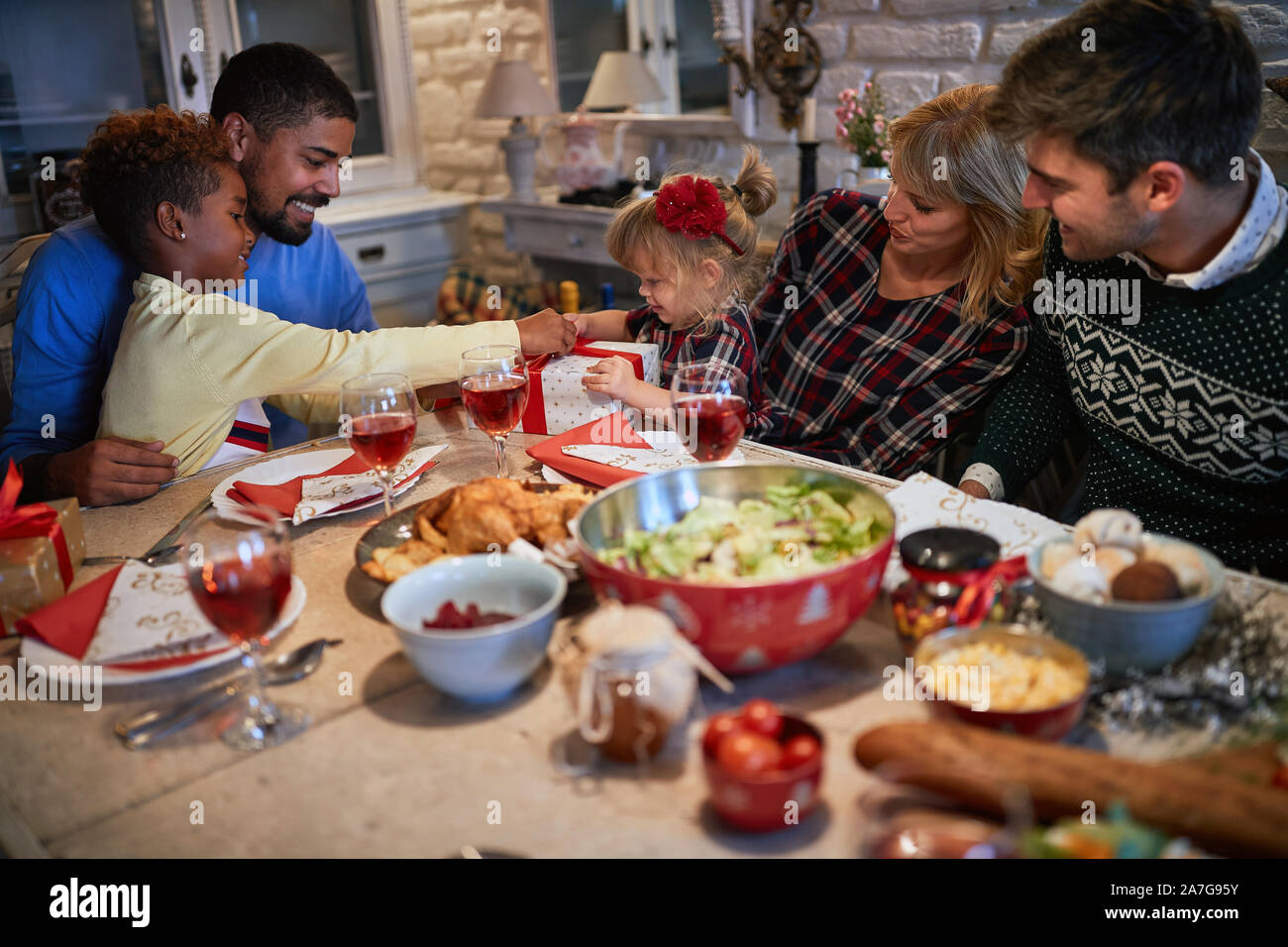 La famiglia felice sono a cena a casa per festeggiare il Natale e di Exchange presente insieme. Foto Stock