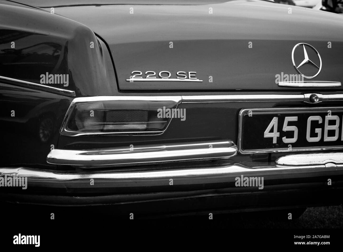 Bianco e nero posteriore sinistra sul quarto di dettaglio di un 1960 (1965) Mercedes 220SE lusso classico tedesco autovettura che mostra i badge di luce, cluster e chrome bu Foto Stock
