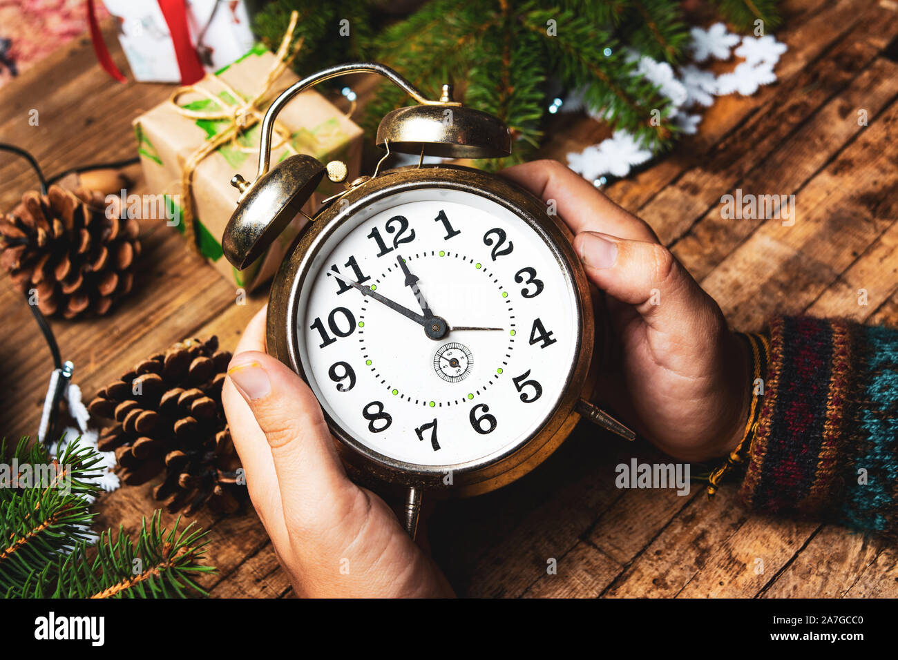 Persona in possesso di un orologio vintage in ambiente festoso pov Foto Stock