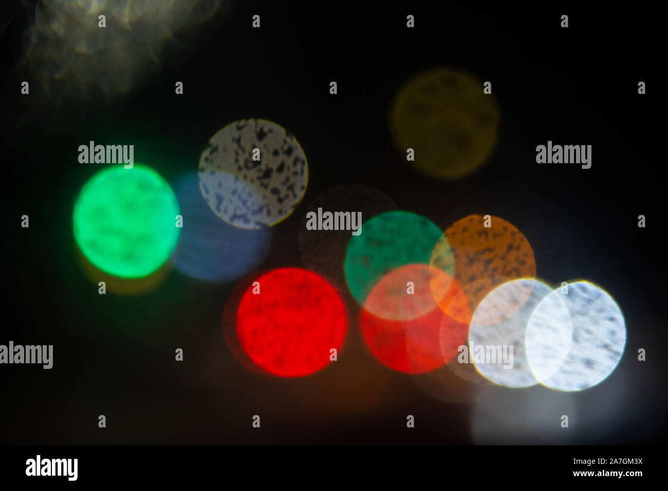 Al di fuori della messa a fuoco abstract fari di automobile di pioggia con spazio per il testo su sfondo scuro Foto Stock