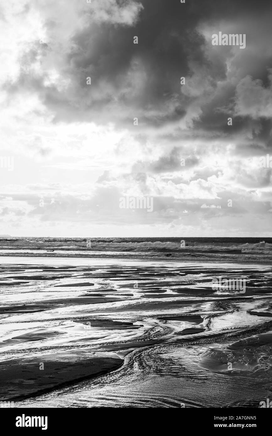 Abstract alto contrasto immagine monocromatica della sabbia e il cielo con le nuvole quasi la metà e metà riempiendo il telaio prese a Woolacombe Beach. Foto Stock