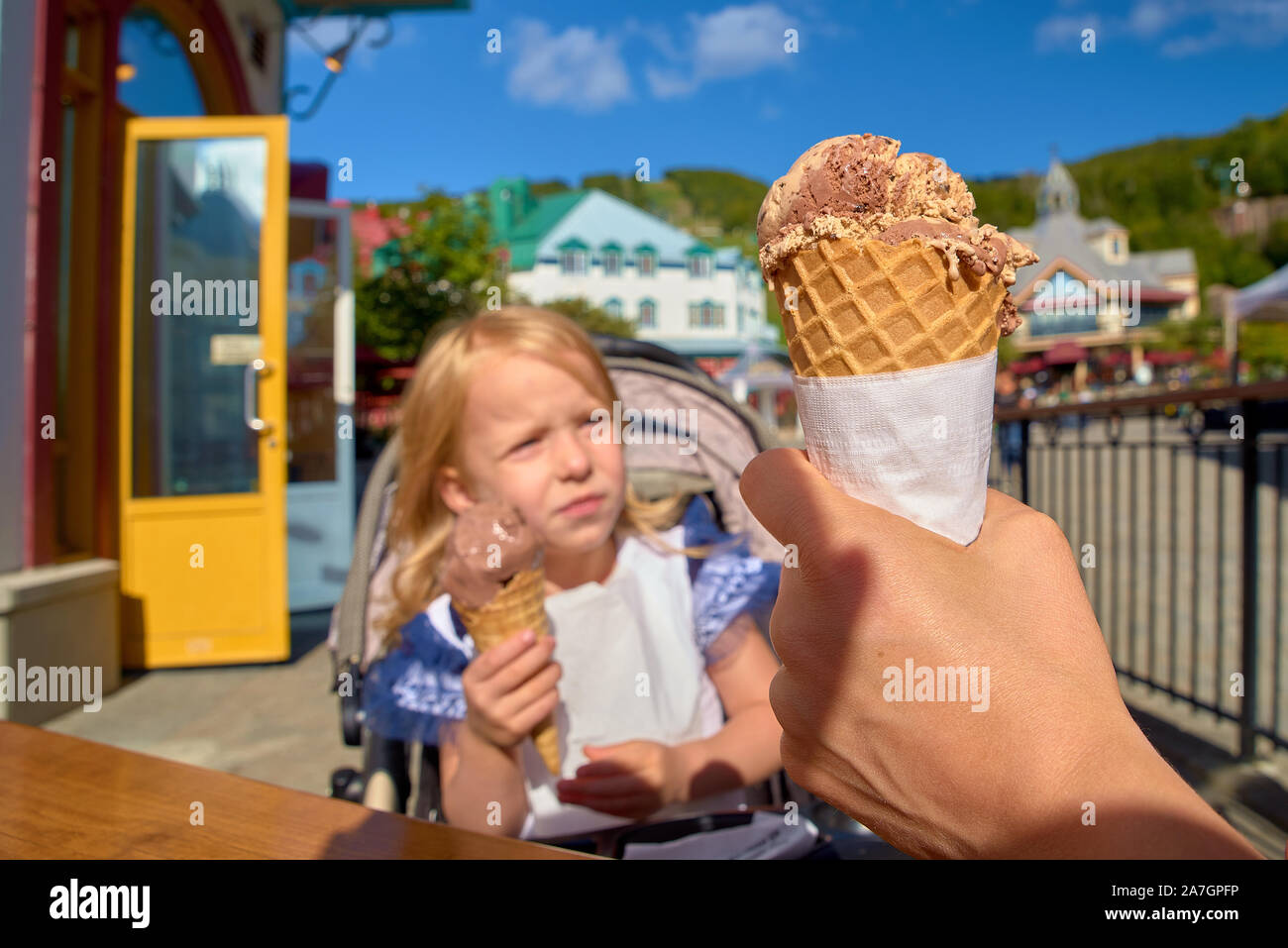 Bambina grande mangia il gelato nel parco. Ritratto di profilo con il fuoco selettivo. Viaggi in Canada. Foto Stock