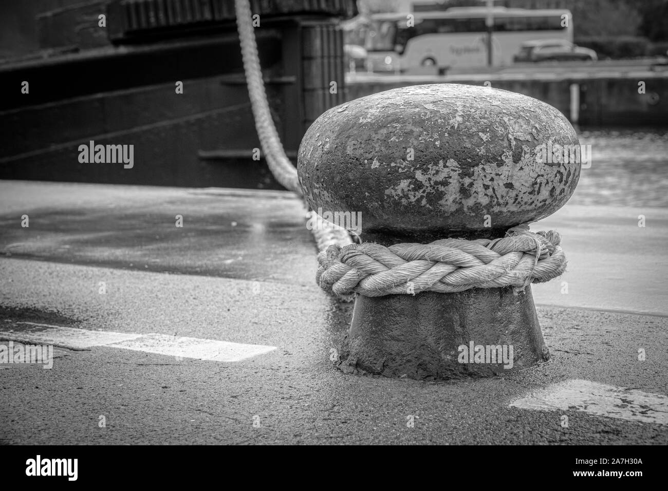 Una nave è attaccato con una spessa corda ad un bollard nel porto Foto Stock