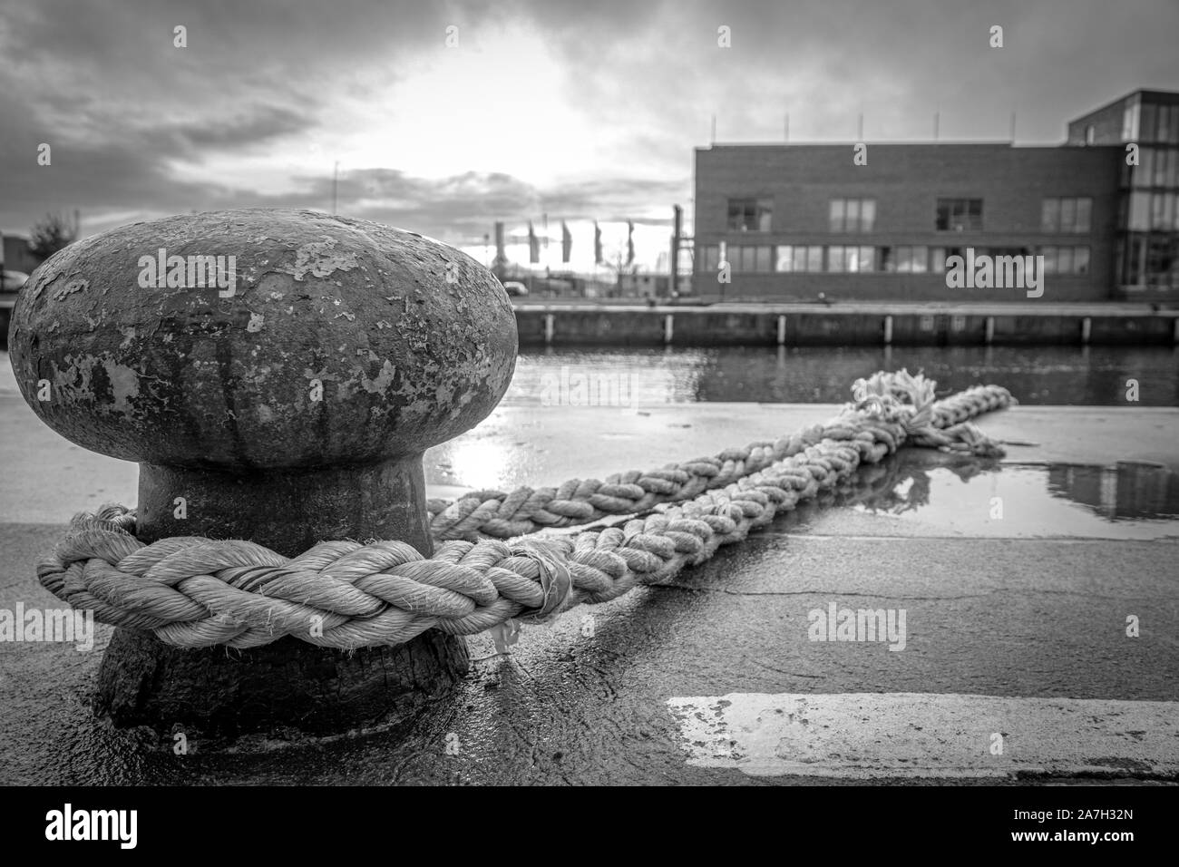 Una nave è attaccato con una spessa corda ad un bollard nel porto Foto Stock