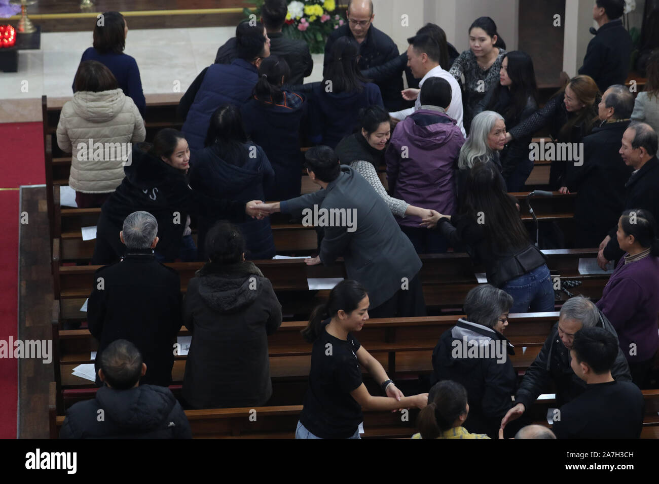 I membri della congregazione nella messa di preghiera e di veglia per la 39 vittime trovati morti all'interno del retro di un autocarro a Grays, Essex, al santo nome di Dio e di Nostra Signora del Sacro Cuore chiesa della Londra la Chiesa vietnamita, nella zona est di Londra. Foto Stock