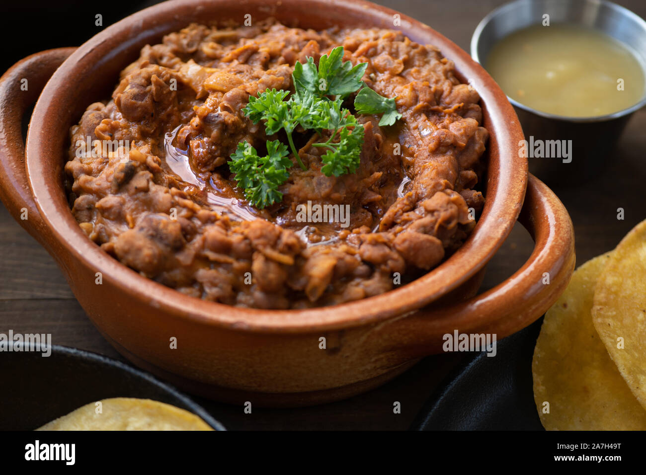 Vegan refried fagioli in pentola di creta Foto Stock