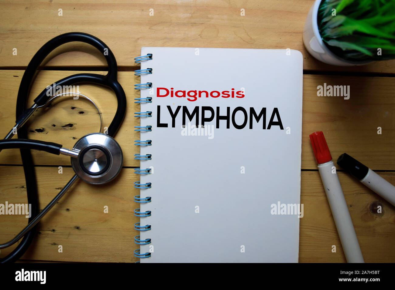 La diagnosi di linfoma di scrivere sul libro con un tavolo di legno sfondo Foto Stock