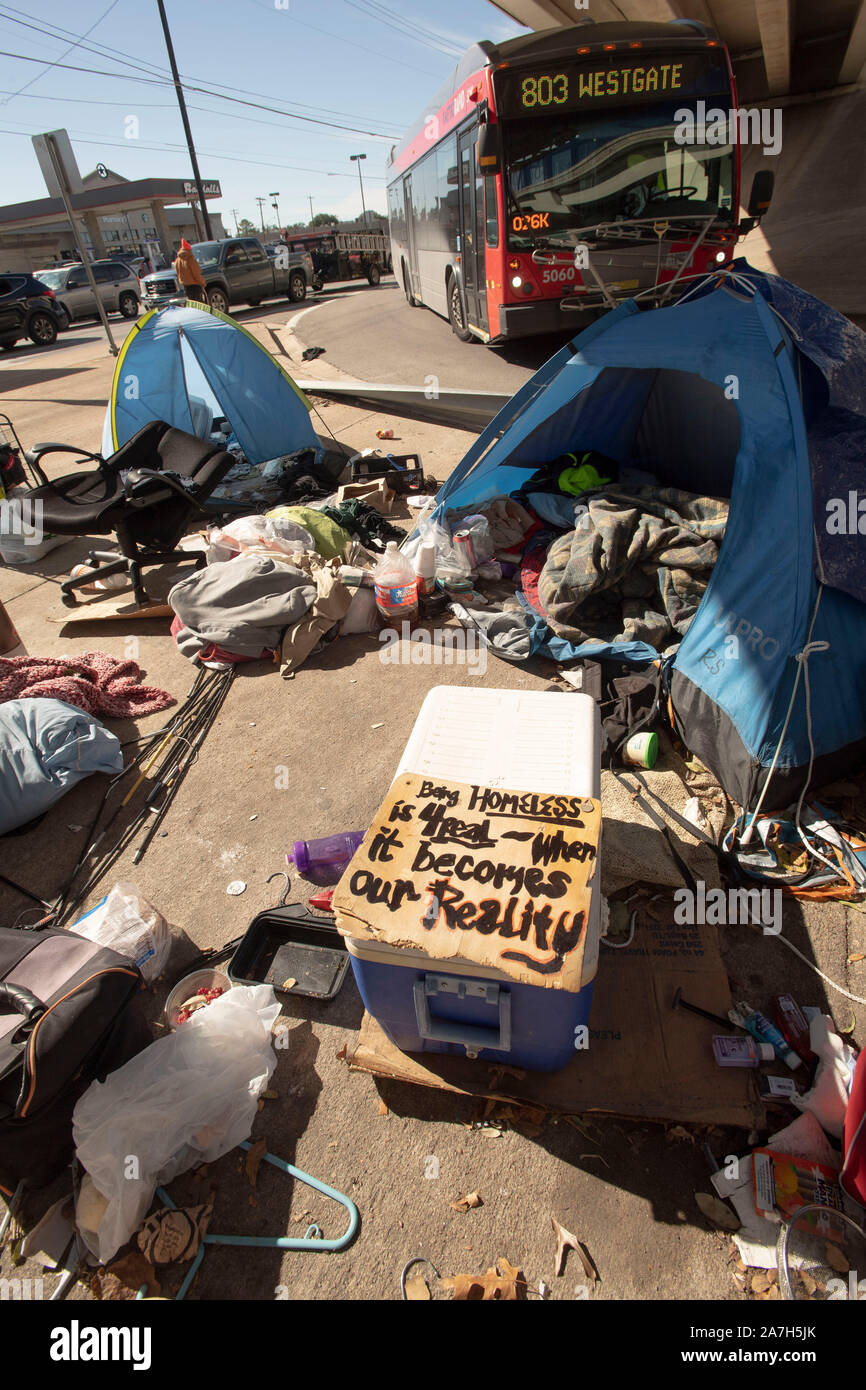 Giorni prima di una repressione minacciato dal governatore del Texas Greg Abbott sul diritto pubblico-di-modo camping, senzatetto Texans attendono l arrivo del dipartimento autostradale cleanup degli equipaggi. La maggior parte sono sicuri dove andranno come rifugi locali sono al di sopra della capacità. Il segno di fronte alla tenda recita "l'essere senzatetto è per veri--quando si tratta della nostra realtà." Foto Stock