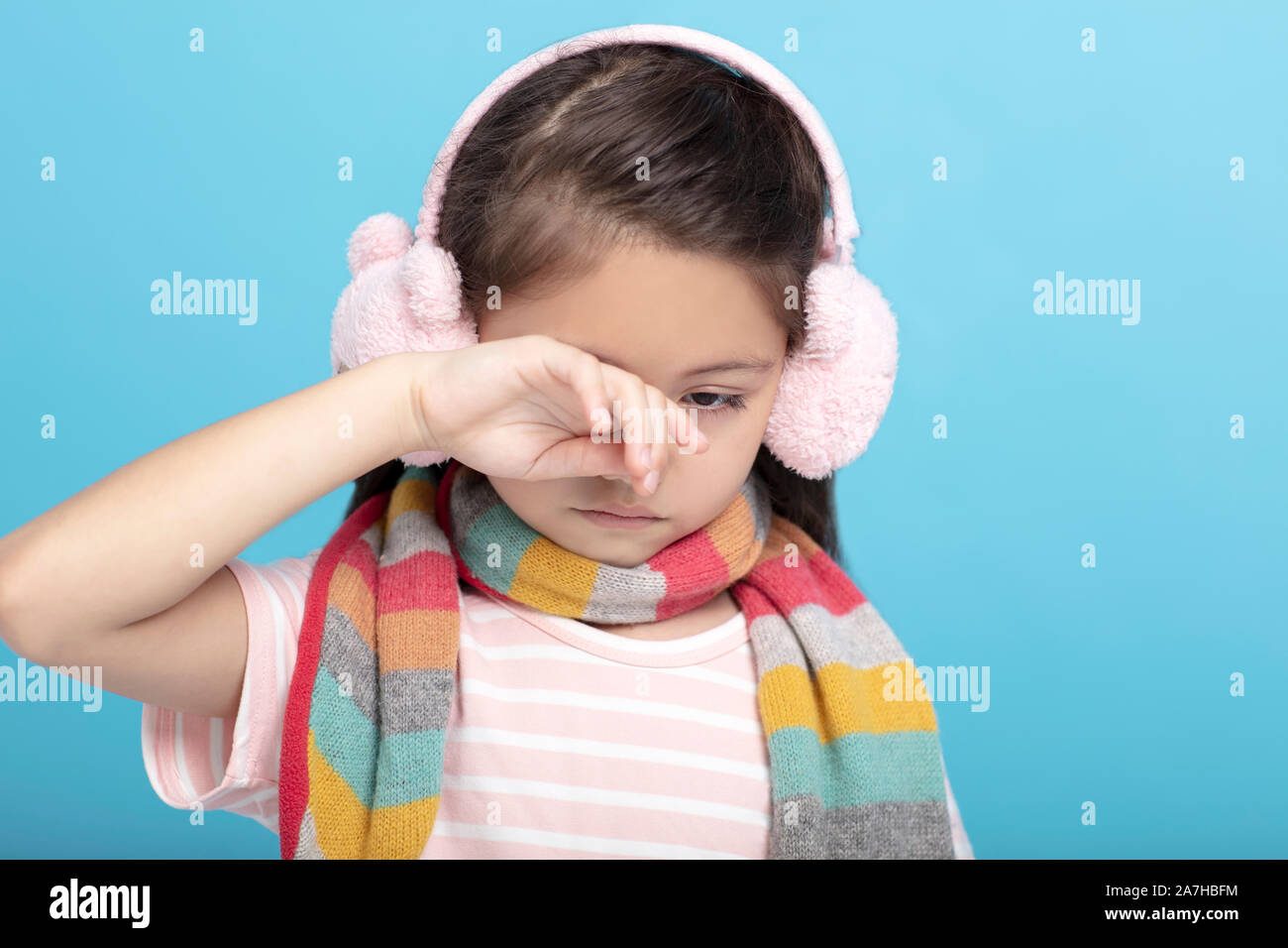 Triste e stanco bambina abiti invernali, guardando verso il basso Foto Stock