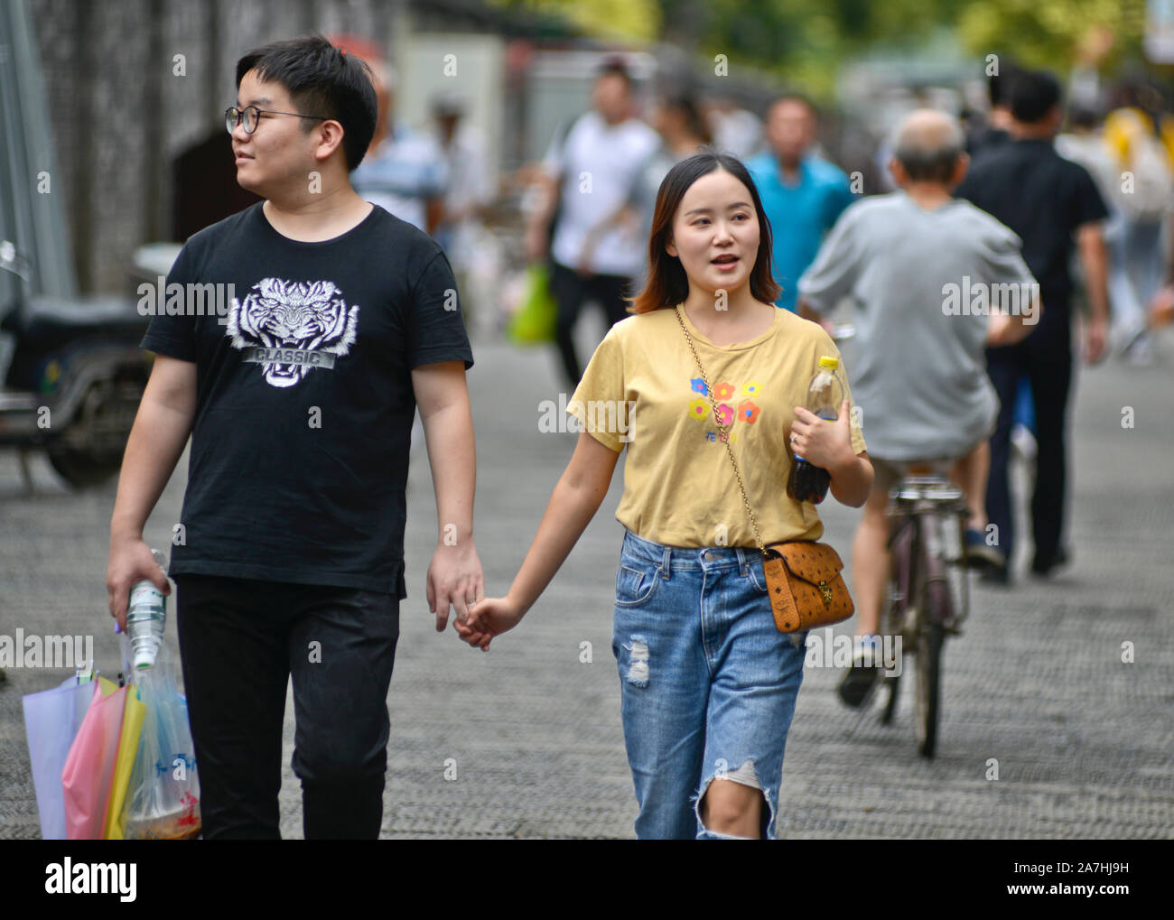 Coppia cinese a piedi tenendo le mani nel vicolo Hubu, Wuhan, Cina Foto Stock