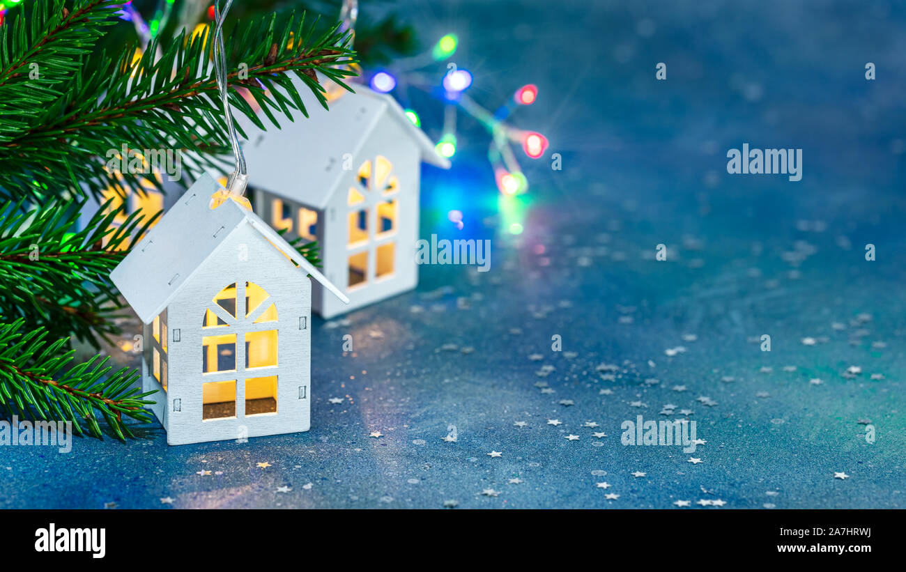 Festa di Natale sfondo. legno decorativo home toy spie verde abete del ramo su sfocate luci incandescenti sfondo Foto Stock