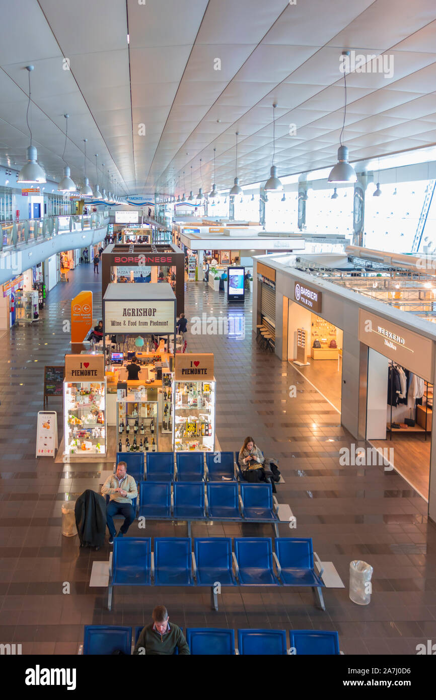 I viaggiatori in attesa presso negozi e negozi presso l'aeroporto di Torino Caselle Foto Stock