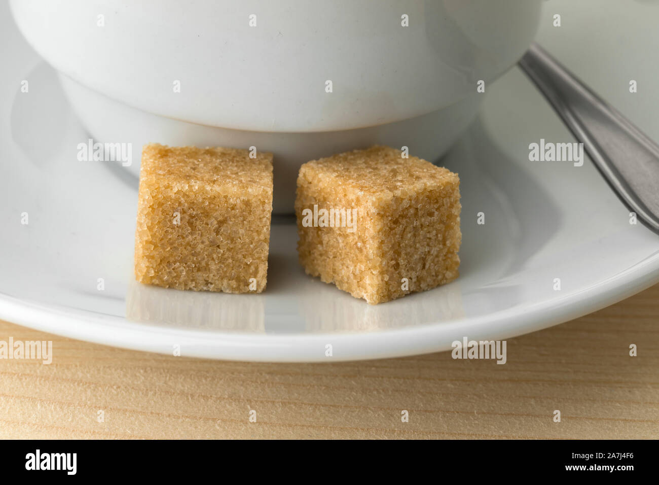 Tazza di caffè con due fairtrade la canna da zucchero Zollette di zucchero da vicino Foto Stock