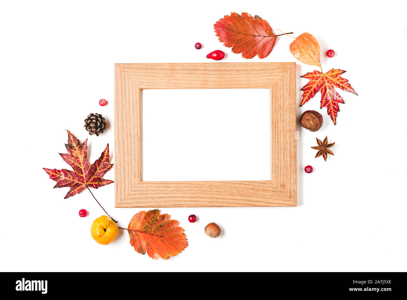 Blank photo frame con mela cotogna, foglie di autunno, noci e bacche su sfondo bianco. La Giornata del ringraziamento concetto. flat laici. vista superiore Foto Stock