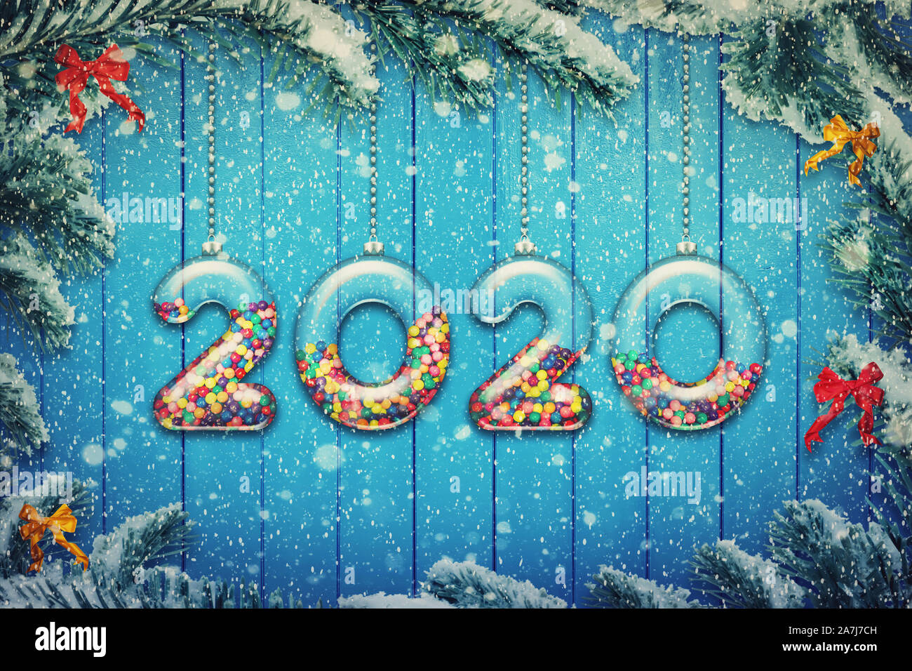 Felice Anno Nuovo 2020 holiday sfondo. Set di numeri trasparente fatta di vetro riempito con multicolore di caramelle e dolci appendere sul Natale nevoso tre Foto Stock