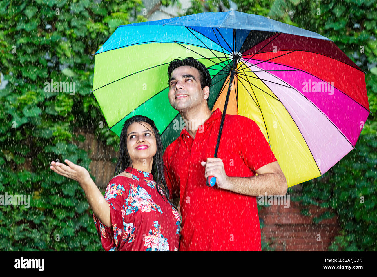 Felice di amare Adulto Giovane sotto ombrellone gustando la pioggia a-park Foto Stock