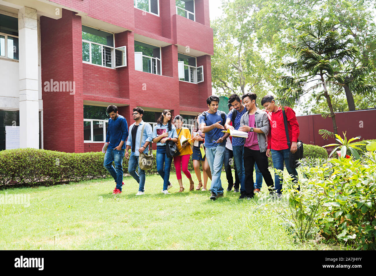 Gruppo di giovani studenti del college amici Leggere Prenota studiando insieme a piedi In-Outside edificio del campus Foto Stock