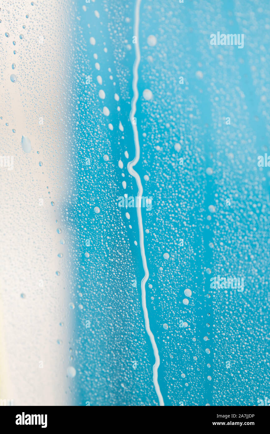 Sfondo blu con la schiuma e di acqua su un vetro o windiow Foto Stock