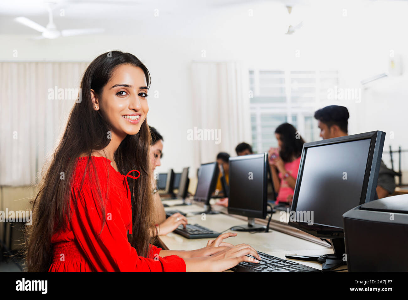 Femmina giovane studente di college utilizzando Computer studiando l'E-Learning con i compagni di classe in aula Foto Stock