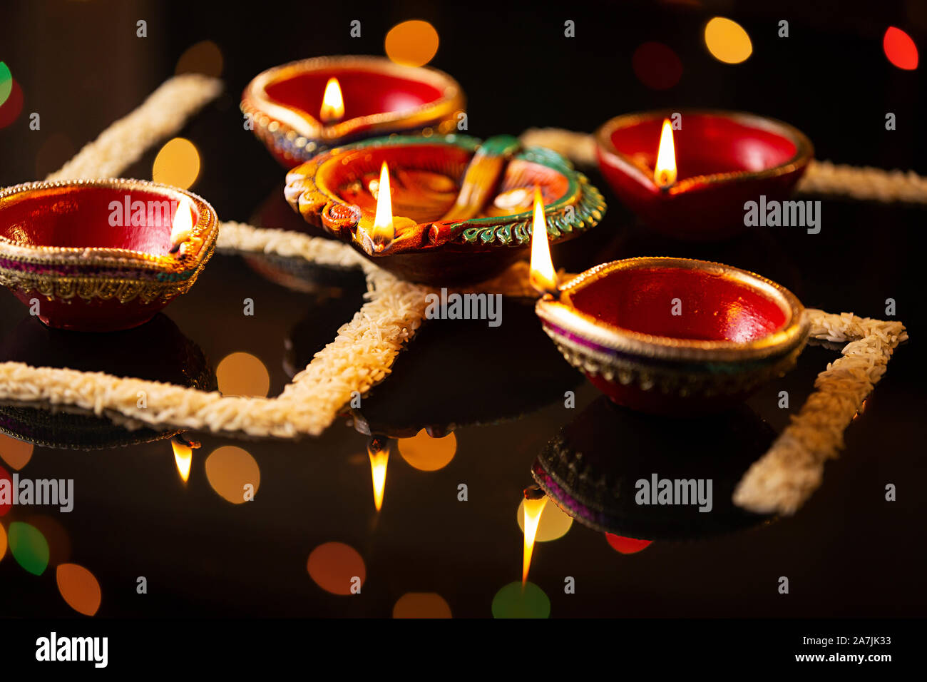 La masterizzazione diyas olio lampade di illuminazione con riso disposte in modo da formare il simbolo swastik il Diwali Festival Foto Stock