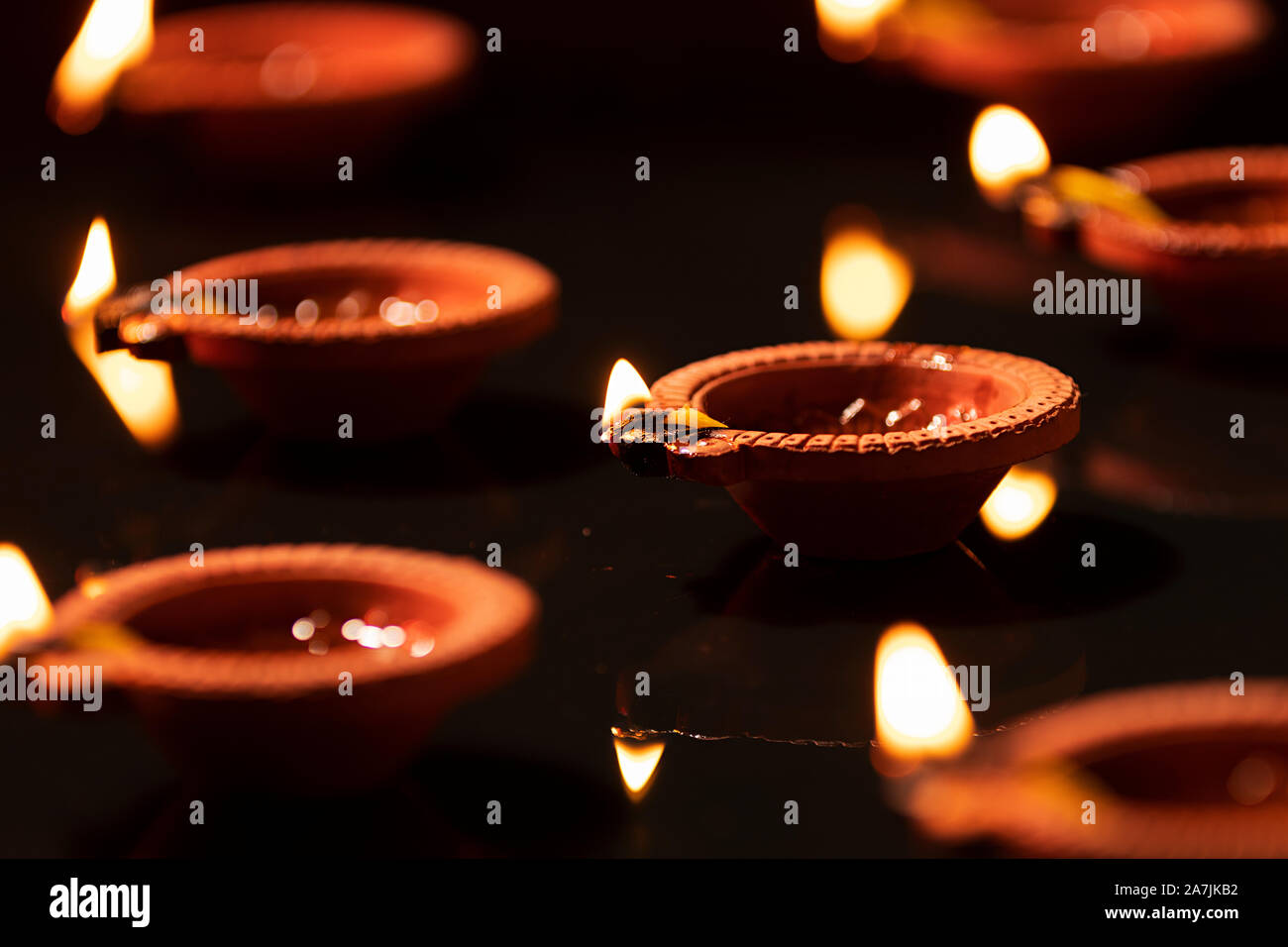 Gruppo diyas argilla con illuminazione e riflessione festa indiano Diwali Festival Foto Stock