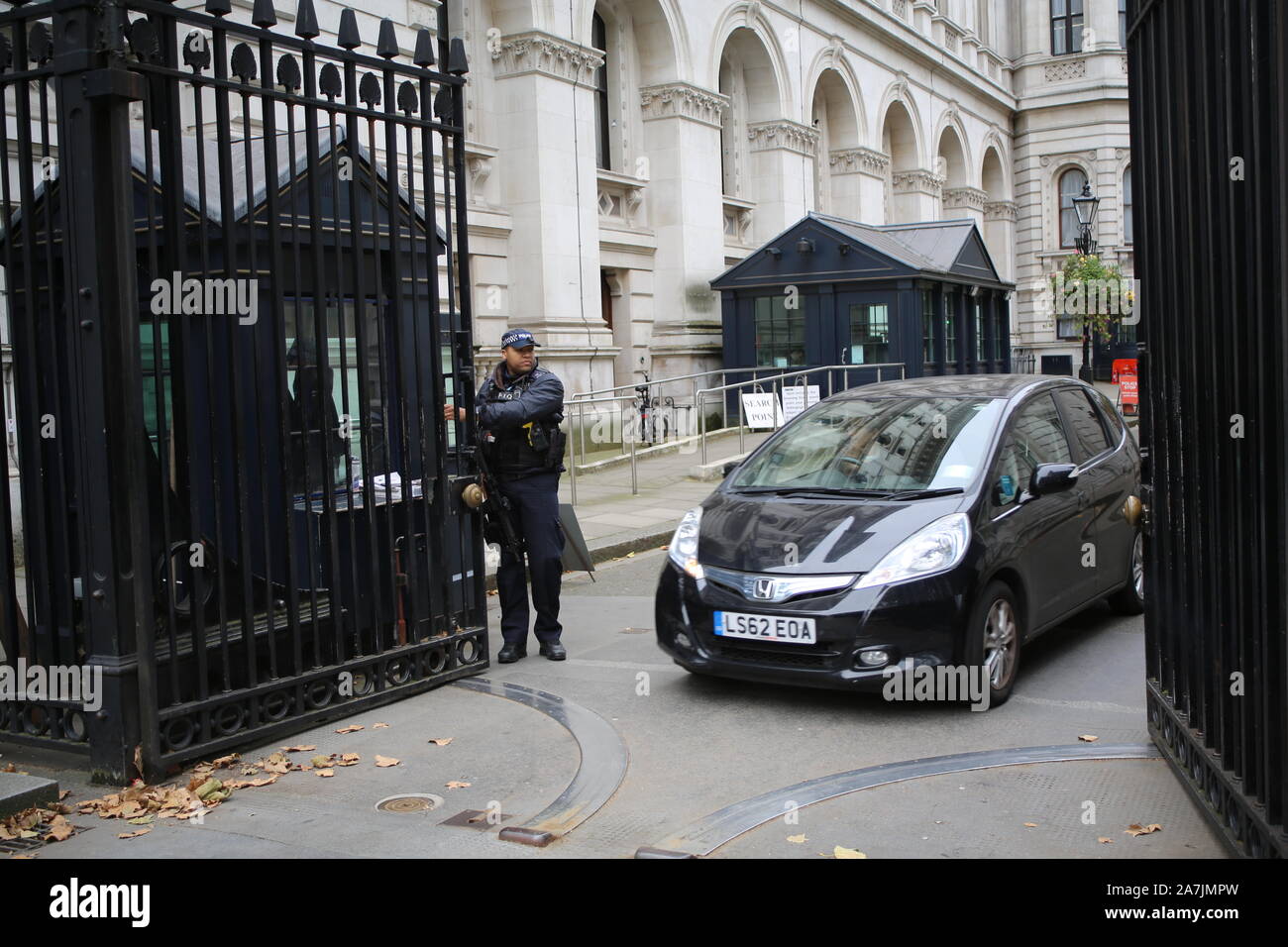 29 ottobre 2019 un auto lascia aperto custodito pesantemente i cancelli di Downing Street, Londra, Regno Unito, casa del Primo ministro britannico e il cancelliere. Foto Stock
