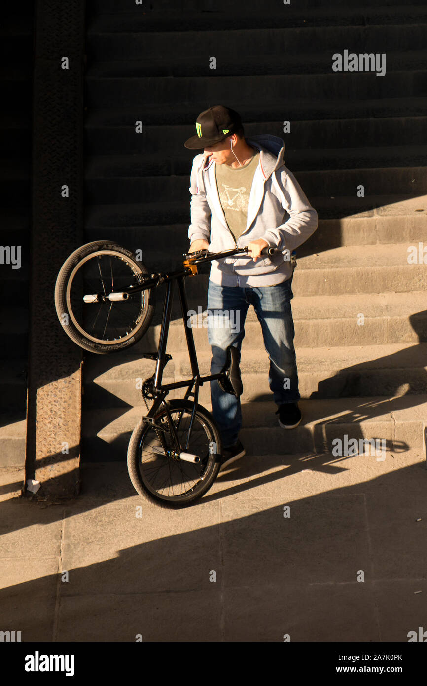 A Belgrado, in Serbia - Ottobre 25, 2019: Un uomo spingendo la bici acrobatica giù il pubblico scale di luce e ombre Foto Stock