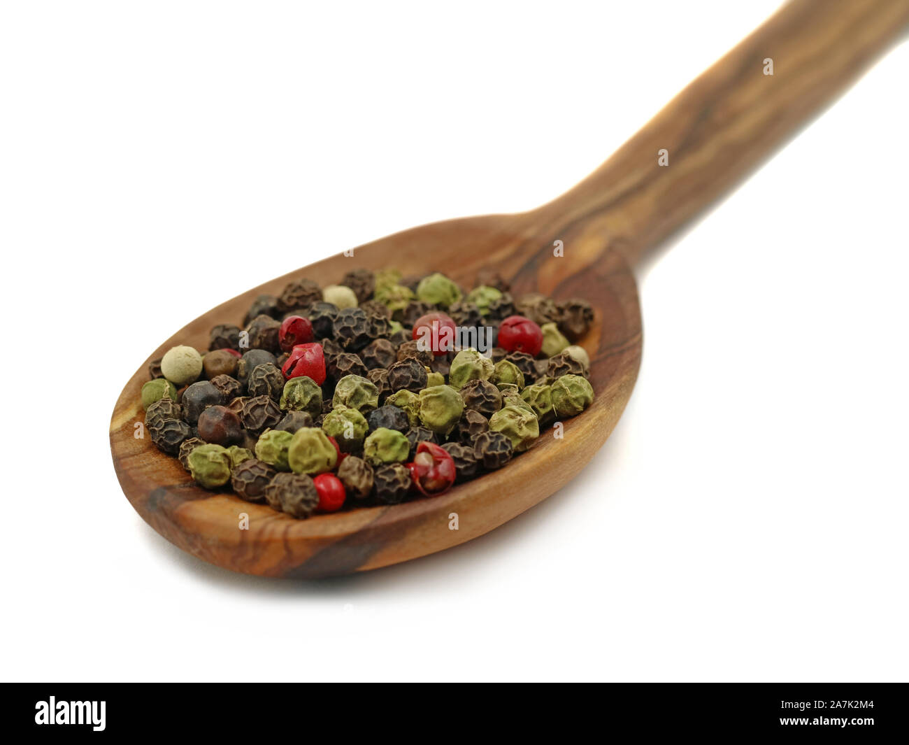 Chiudere il cucchiaio di legno con pepe mix isolati su sfondo bianco. Nero, rosso, verde e pepe bianco macro shot Foto Stock