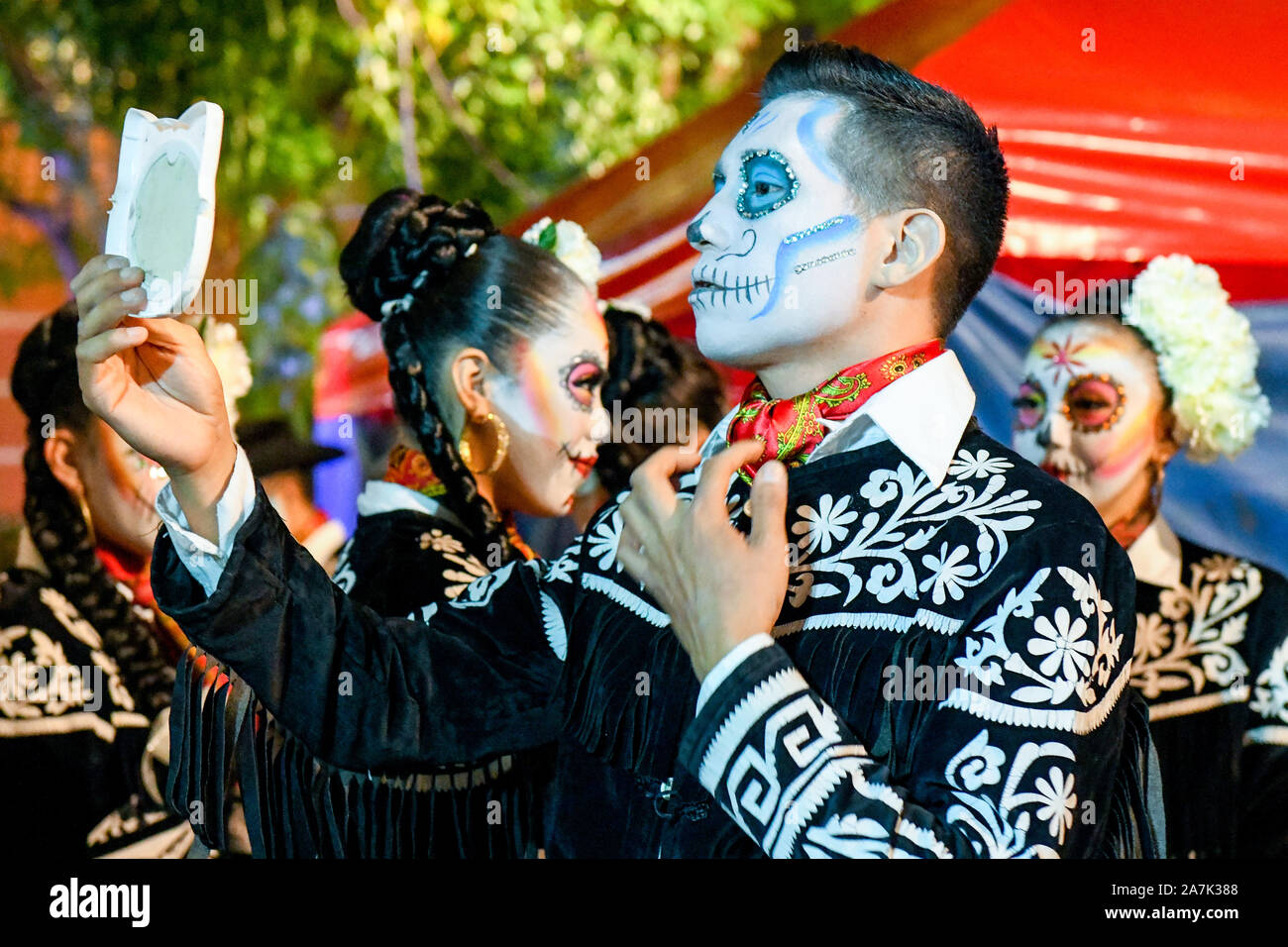 Mariachi performer di applicare il make-up prima di uno spettacolo durante il festival Las Animas, Hanal Pixan, Merida, Messico Foto Stock