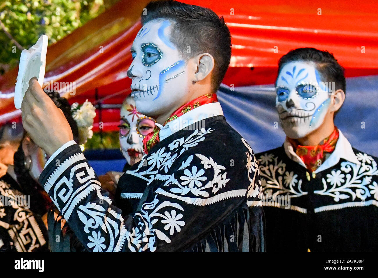 Mariachi performer di applicare il make-up prima di uno spettacolo durante il festival Las Animas, Hanal Pixan, Merida, Messico Foto Stock