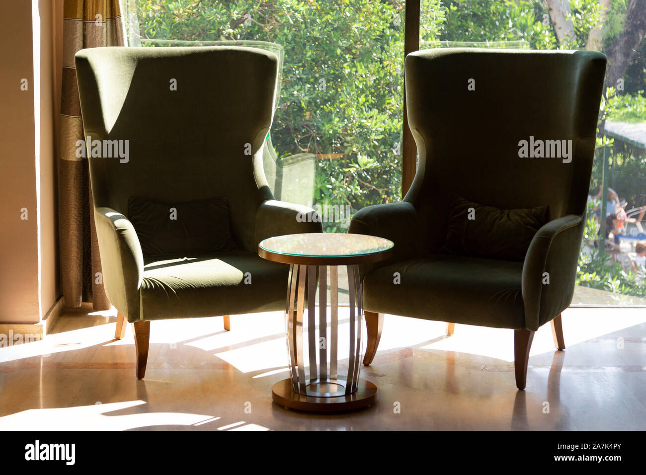 Due sedie di velluto verde e un tavolino da caffè. Foto Stock