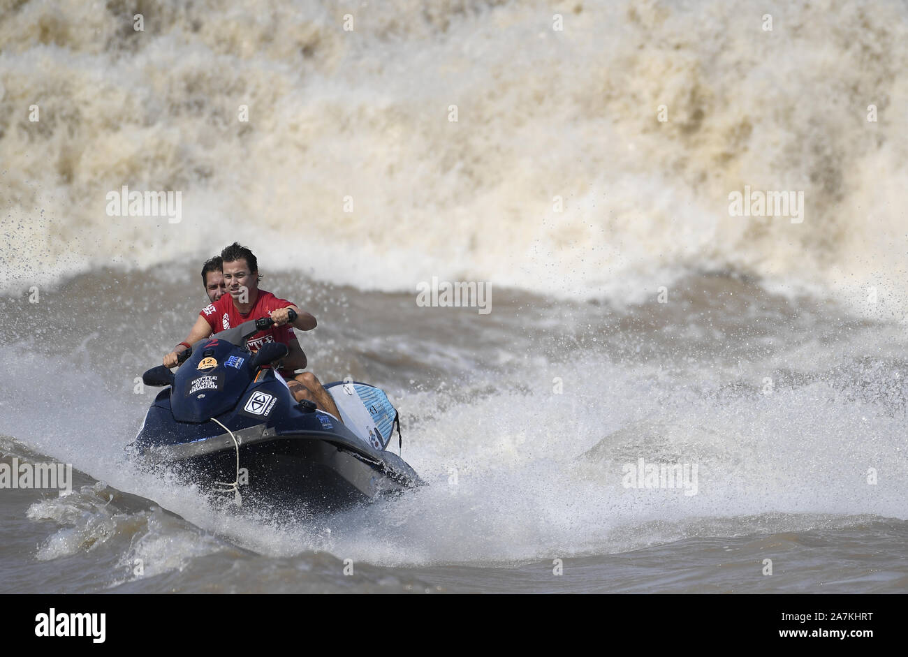 Surfisti cavalcare un onda sul Fiume Qiantang in Hangzhou, Oriente Cina¯s nella provincia di Zhejiang, 16 settembre 2019. Foto Stock