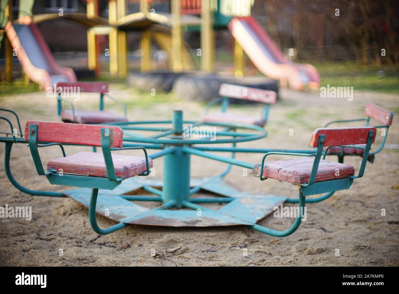 Parco giochi per bambini con una vecchia giostra nella sabbia. Foto Stock