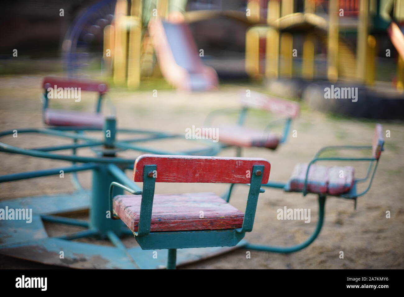 Parco giochi per bambini con una vecchia giostra nella sabbia closeup. Foto Stock