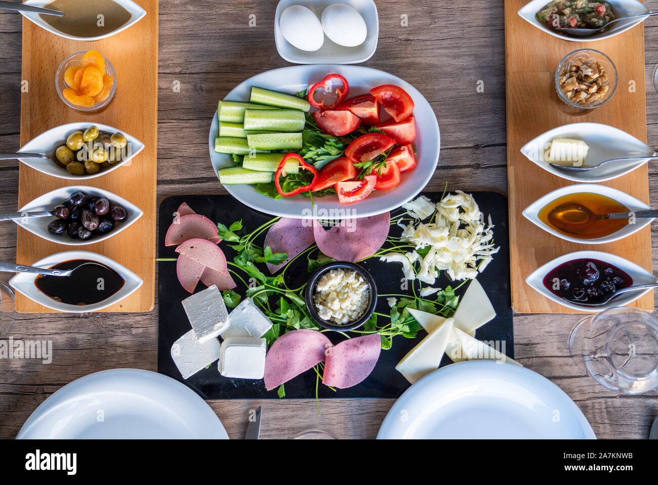 Preparazione di una ricca colazione mediterranea per un gruppo. Foto Stock