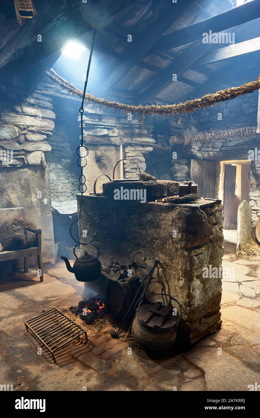 Interno della fattoria Kirbuster Museum, un firehoose, che mostra il centro di camino di pietra, torba fuoco e appendere il bollitore, Kirbuster, Continentale, Orkney, Scotl Foto Stock