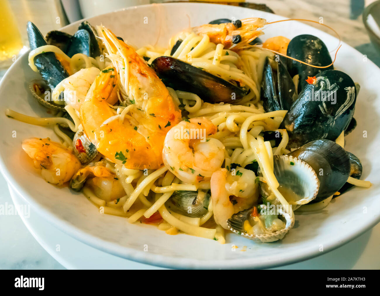 Seafood Linguini pasta con cozze crevettes cardidi re boreale con peperoncino e aglio pane è servita in un ristorante specializzato Foto Stock