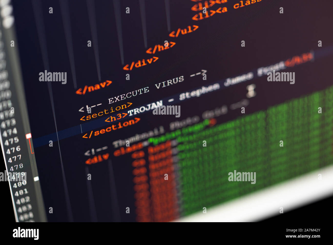 Un primo piano dello schermo di un computer che mostra la codifica in html e le parole di virus e trojan. Concetto - sicurezza informatica, virus hacking e cavalli di troia Foto Stock