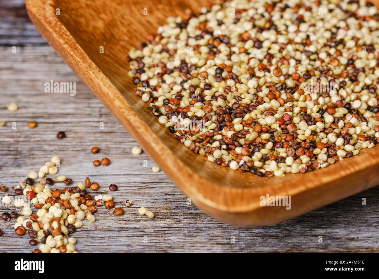 Materie di quinoa calli in una ciotola di legno su una superficie di legno Foto Stock
