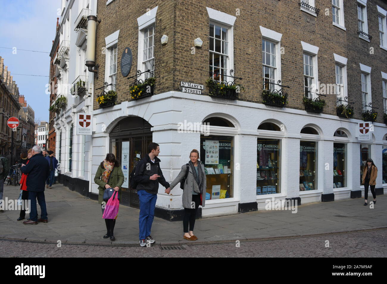 Coppia giovane holding hands in strada al di fuori Cambridge University Press bookshop, Cambridge, Cambs., Inghilterra Foto Stock