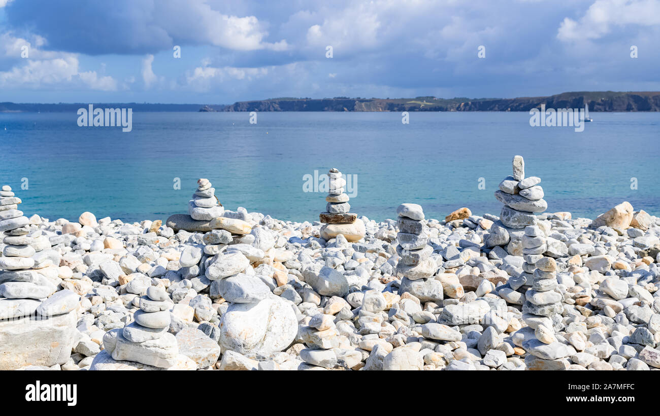 Cairns in Bretagna, il mare e le scogliere in estate in background Foto Stock