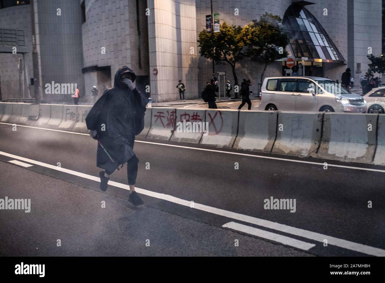 Hong Kong, Cina. 02Nov, 2019. Un manifestante viene eseguito a mezzo di una nube di gas lacrimogeno durante una evacuazione in Central.Hong Kong manifestanti dimostrano per la ventiduesima weekend consecutivi nel distretto centrale di Hong Kong. I manifestanti continuano a chiamare per Hong Kong di Chief Executive Carrie Lam per soddisfare le loro esigenze rimanenti poiché la controversa legge in materia di estradizione è stata ritirata, che include un inchiesta indipendente sulla polizia brutalità, la ritrazione della parola "riot' per descrivere le manifestazioni, e vero e proprio suffragio universale. Credito: SOPA Immagini limitata/Alamy Live News Foto Stock