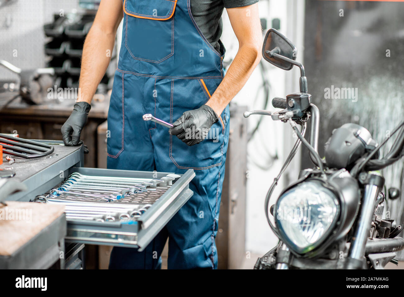 Mechanic come ottenere le chiavi dal metallo tool box, riparazione di moto in officina, close-up Foto Stock