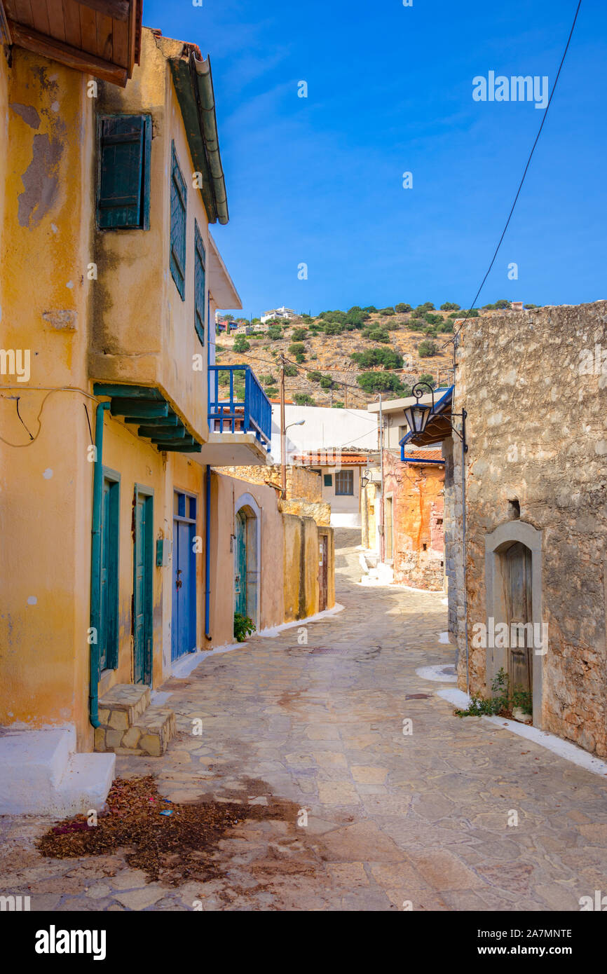 Strada stretta con coloratissime case di pietra nel vecchio villaggio di Pano Elounda, Creta, Grecia. Foto Stock