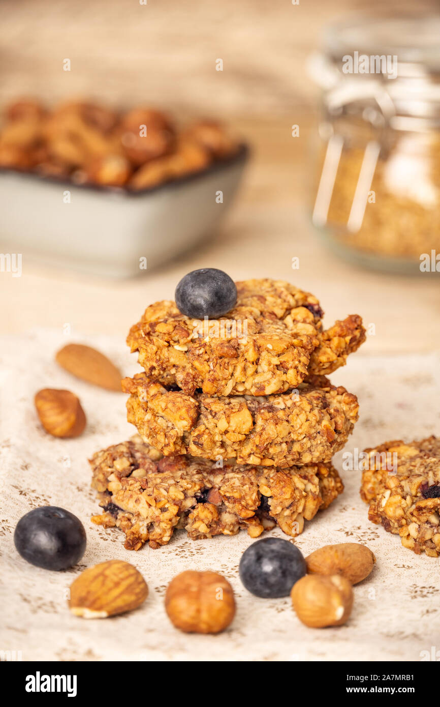 In casa di crusca di avena cookie con mirtilli, nocciole, mandorle e noci. Cibo sano. Composizione verticale. Foto Stock