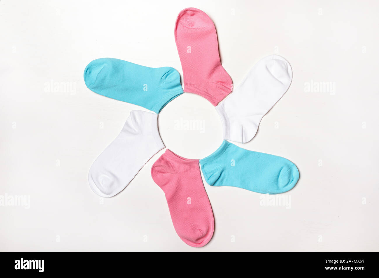 Multi-colore di calze corte giacente nella forma di un fiore su uno sfondo bianco. Vista dall'alto. Foto Stock