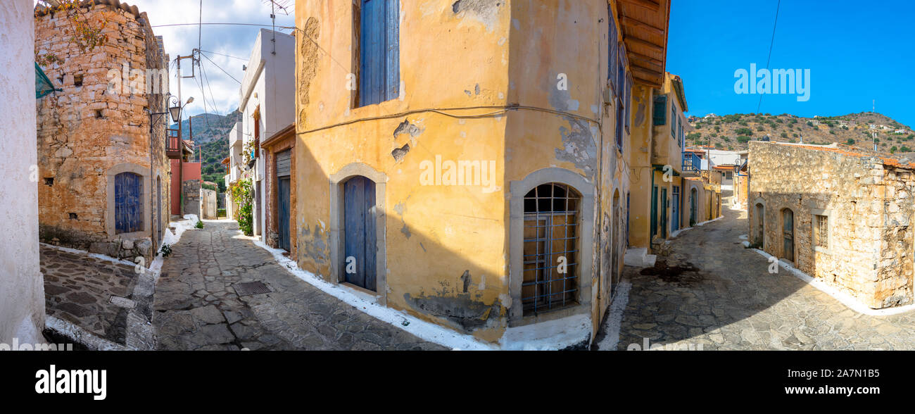 Strada stretta con coloratissime case di pietra nel vecchio villaggio di Pano Elounda, Creta, Grecia. Foto Stock